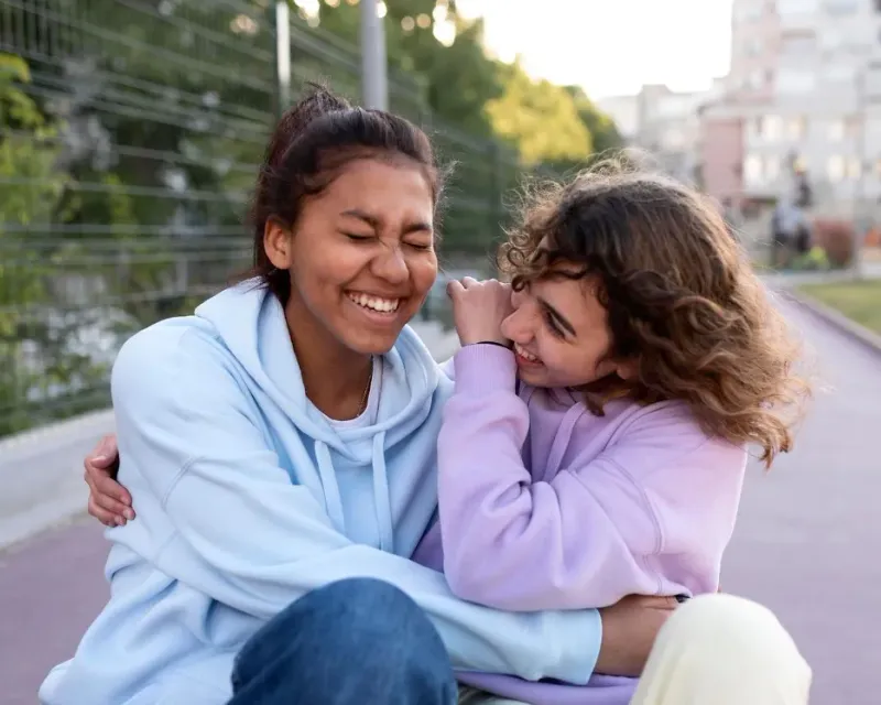 Two colleagues laughing together outdoors
